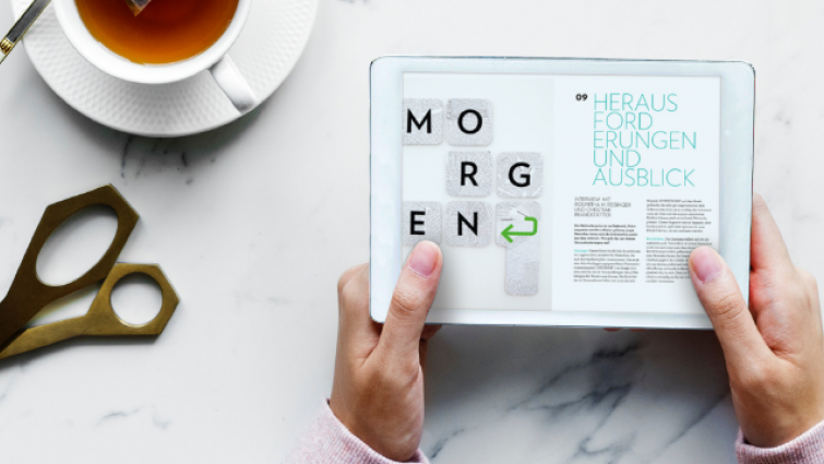 Man sieht Hände, die ein Tablet halten, auf dem 